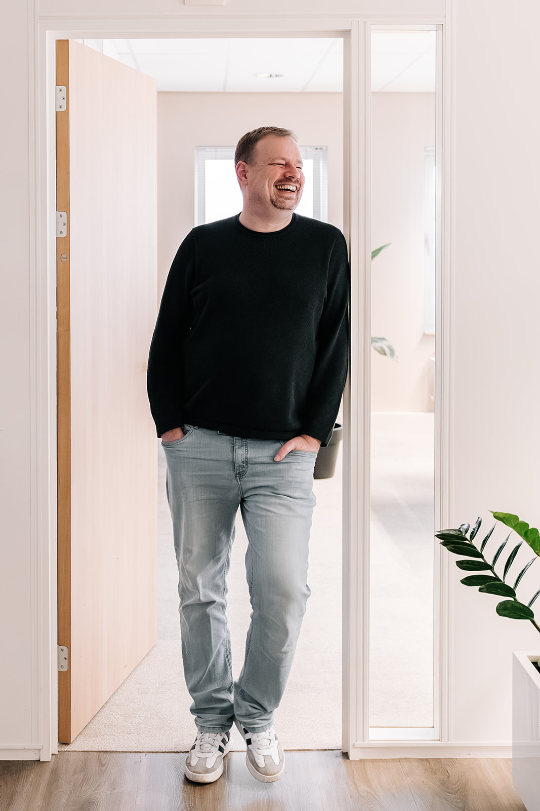 Man leunt tegen deurpost