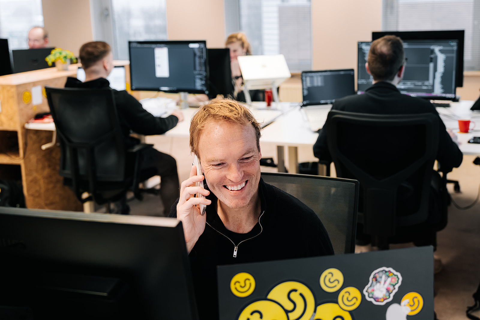 Man achter laptop aan het bellen