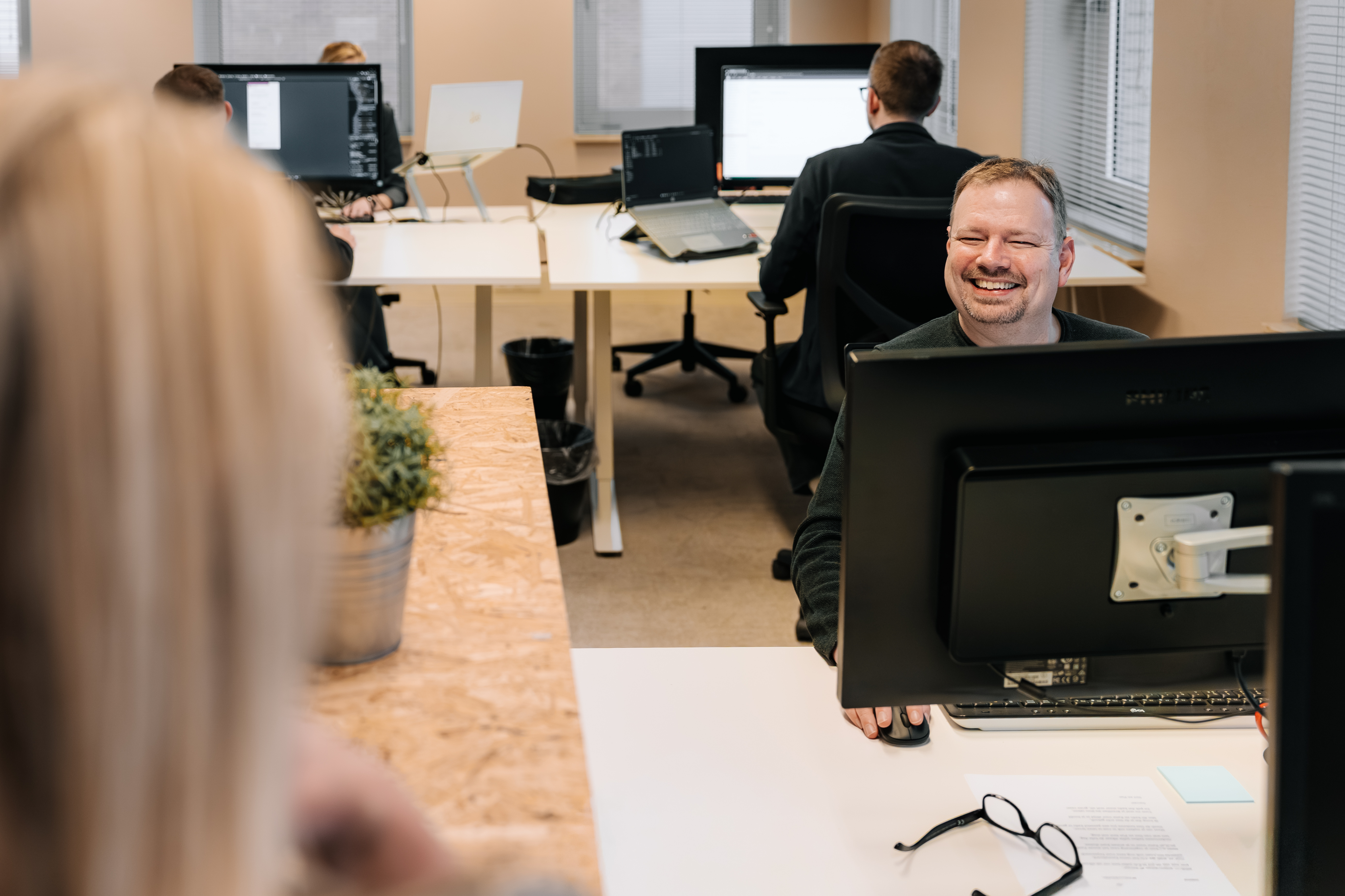 Lachende man achter laptop op een kantoor