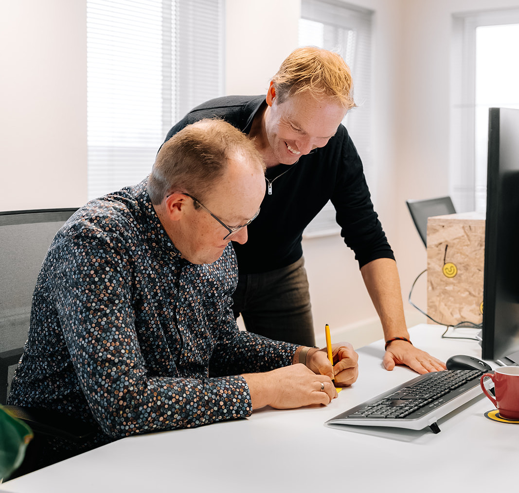 Man maakt notities achter computer